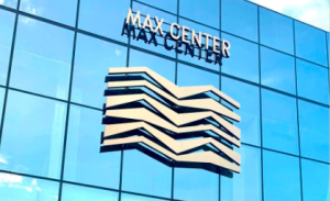 Se ve la fachada de un edificio con el logo de Max Center